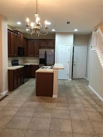 a kitchen with stainless steel appliances granite countertop a refrigerator and a stove top oven