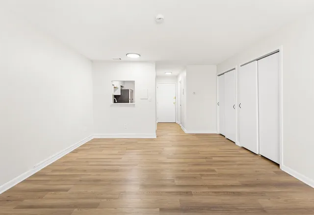a view of an empty room with wooden floor