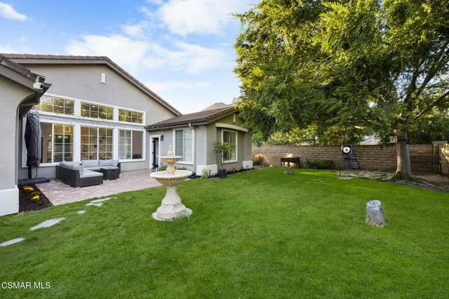 a front view of a house with a yard and trees