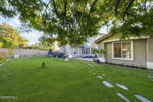 a front view of a house with a garden and trees