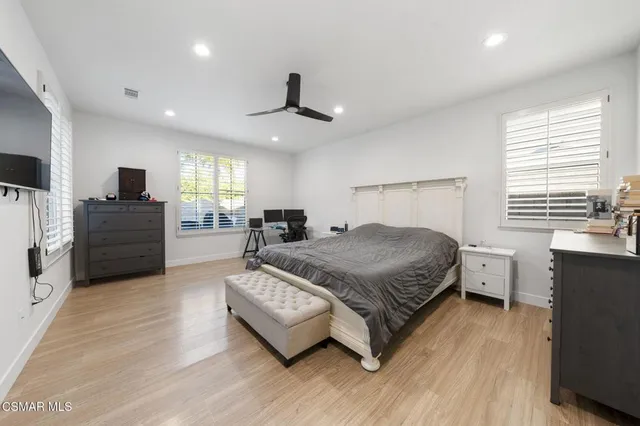 a spacious bedroom with a bed and a flat screen television