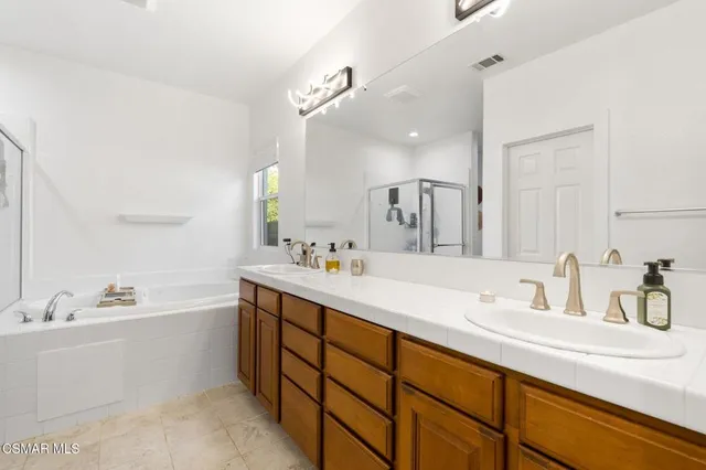 a bathroom with a double vanity sink mirror double and bathtub