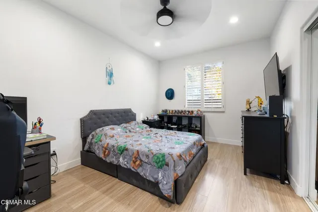 a bedroom with a bed and a flat tv screen on dresser
