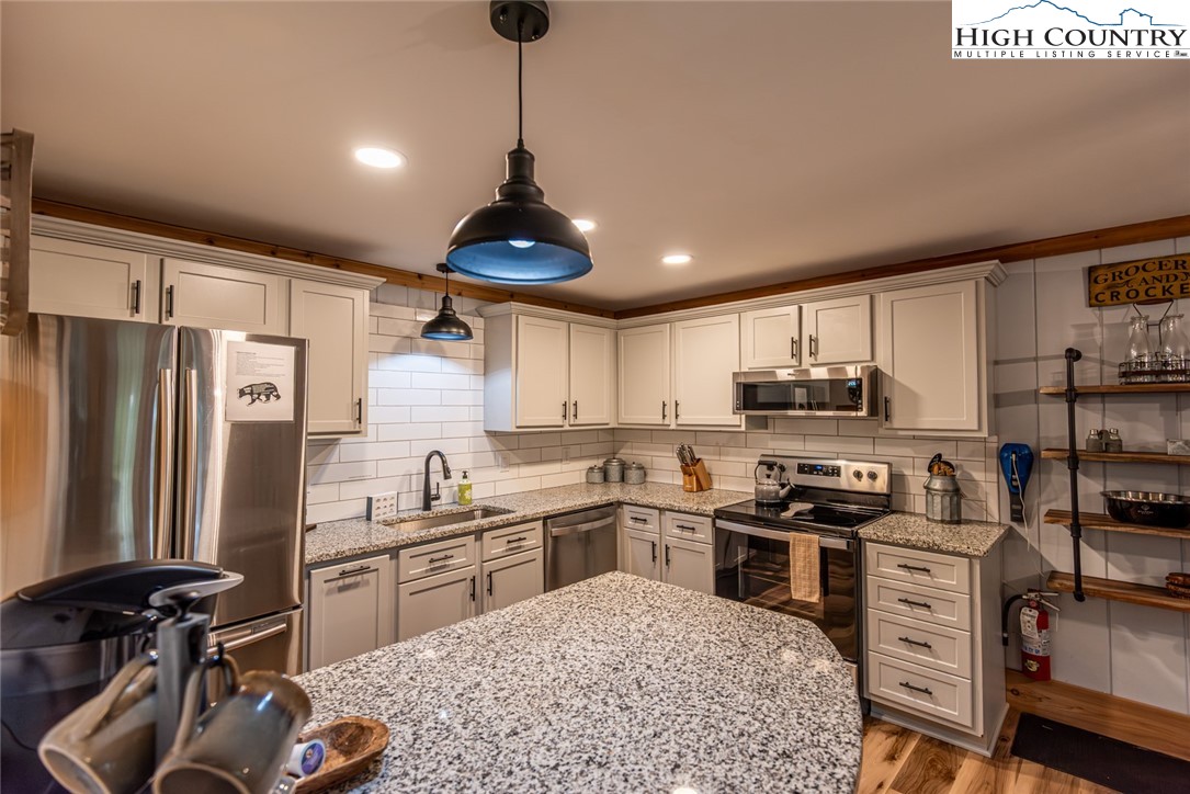 220 Charter Hills Road, Unit A2 Beech Mountain, NC 28604 - Photo 11 of 30 a kitchen with stainless steel appliances granite countertop a sink stove and refrigerator