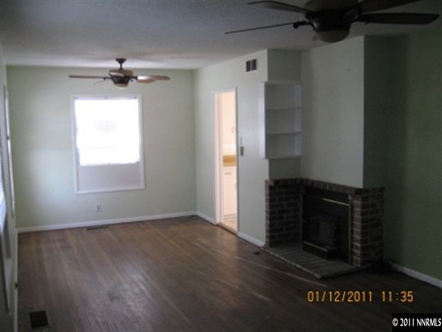 901 Delmar Way Reno, NV 89509 - Photo 2 of 10 an empty room with wooden floor cabinet and windows