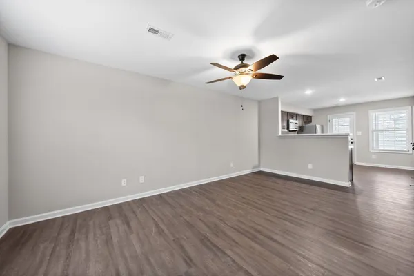 a view of a kitchen with wooden floor and a ceiling fan