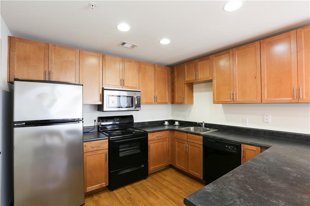 711 West 32nd Street, Unit 107 Austin, TX 78705 - Photo 6 of 25 a kitchen with a refrigerator sink and cabinets