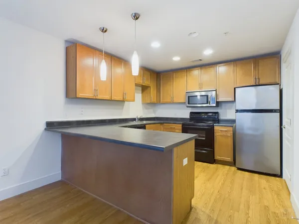 a kitchen with stainless steel appliances granite countertop a refrigerator a stove and a sink