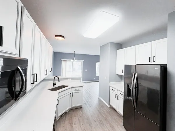 a kitchen with refrigerator a sink and cabinets