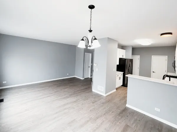 a view of a kitchen with furniture and stainless steel appliances