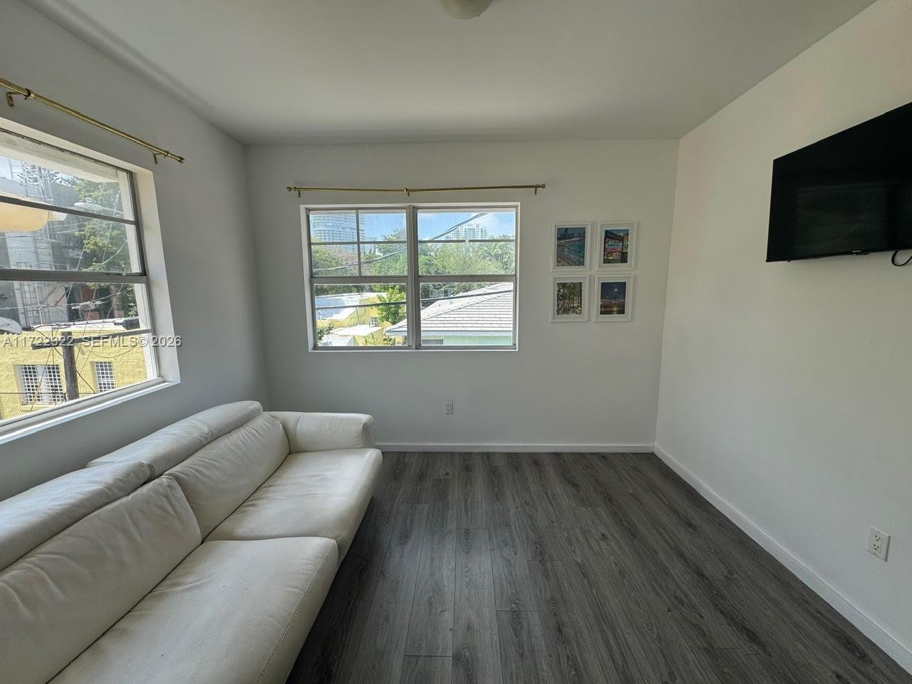 810 7th Street, Unit 207 Miami Beach, FL 33139 - Photo 5 of 16 a living room with furniture and a flat screen tv