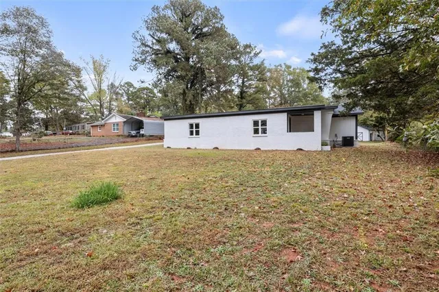 a white house with a large tree in front of it