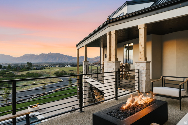 923 North Emery Lane Elk Ridge, UT 84651 - Photo 88 of 101 Expansive outdoor patio featuring a built-in fire pit with lava rocks, durable stone tile flooring, and a contemporary black metal railing