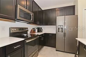 a kitchen with stainless steel appliances granite countertop a refrigerator and a stove top oven