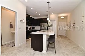 a kitchen with kitchen island a sink stainless steel appliances and cabinets