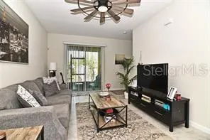 a living room with furniture a flat screen tv and a window