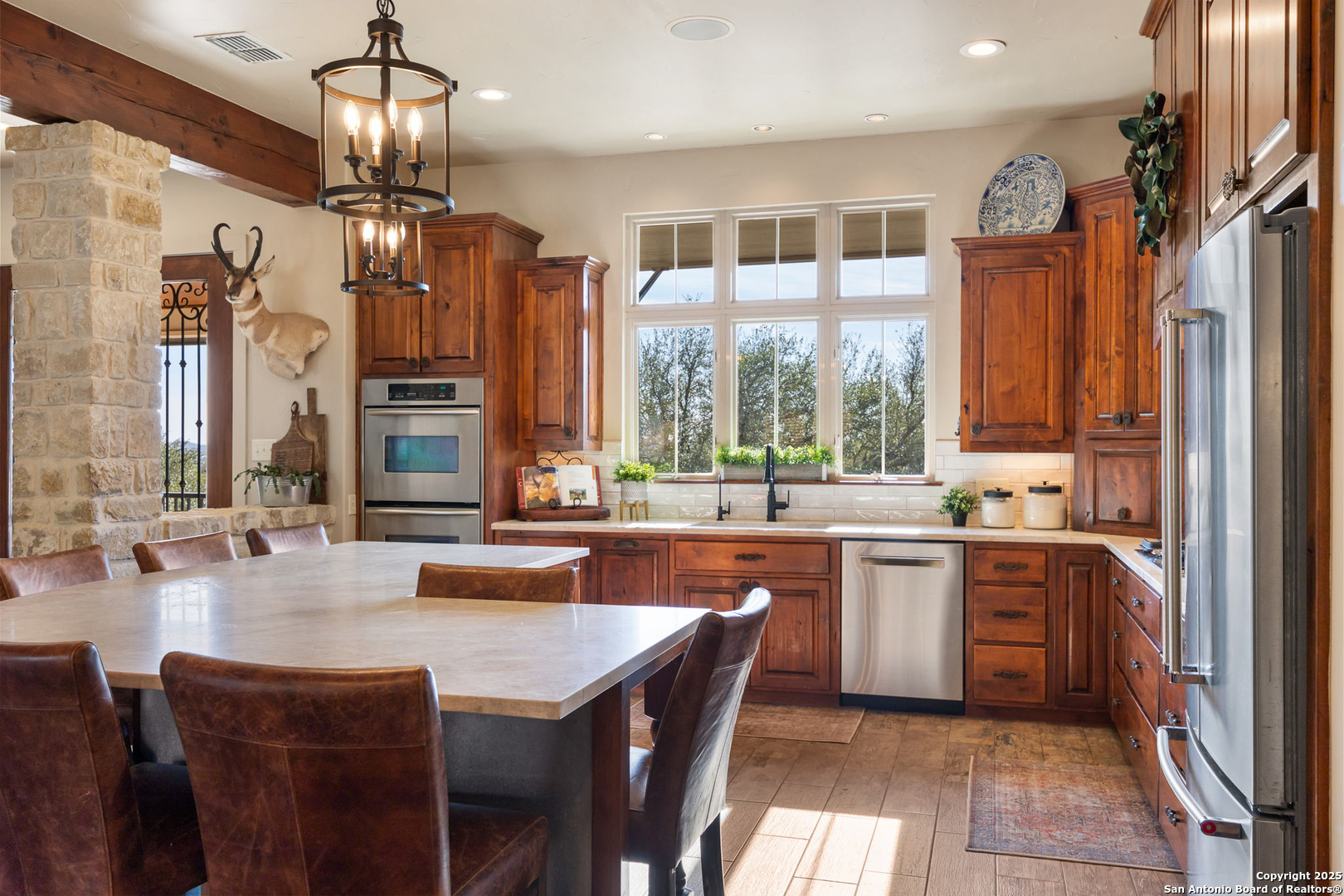 115 Spanish Pass Road Boerne, TX 78006 - Photo 8 of 50 a kitchen with stainless steel appliances granite countertop a stove top oven a sink dishwasher a dining table and chairs with wooden floor