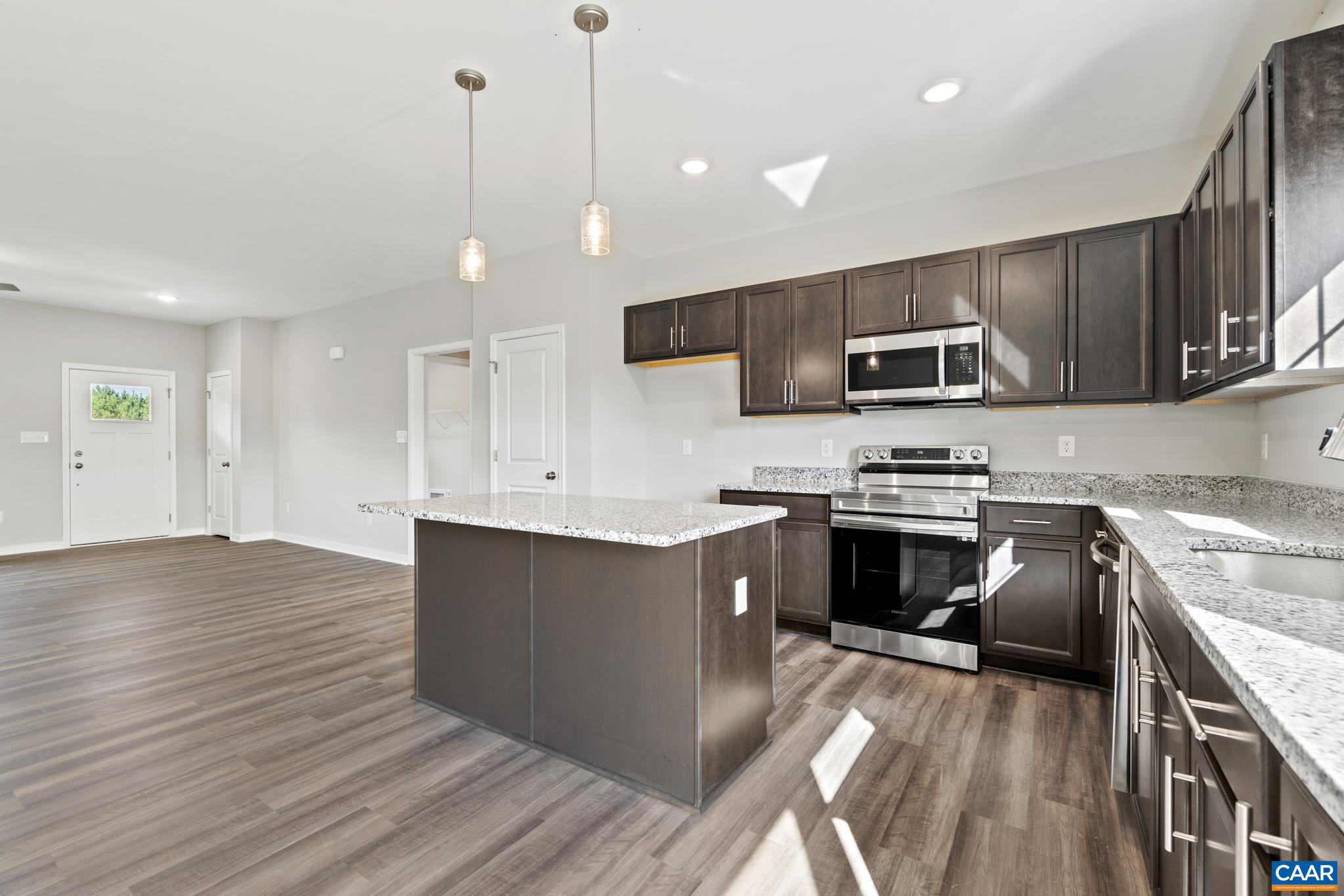 Lot 4 Hells Bend Road Palmyra, VA 22963 - Photo 7 of 21 a kitchen with granite countertop a stove top oven a sink dishwasher a refrigerator and a dining table with wooden floor