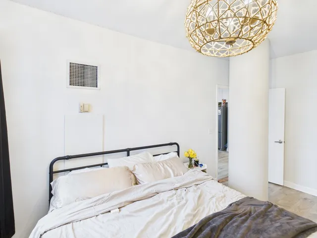 a bedroom with a bed and a chandelier