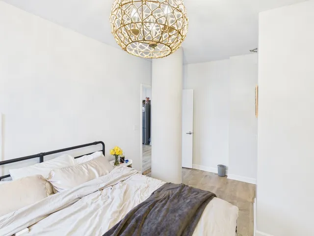 a bedroom with a bed and a chandelier