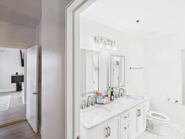 a bathroom with a double vanity sink mirror and toilet