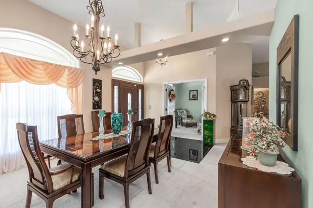 a view of a dining room with furniture a chandelier and window