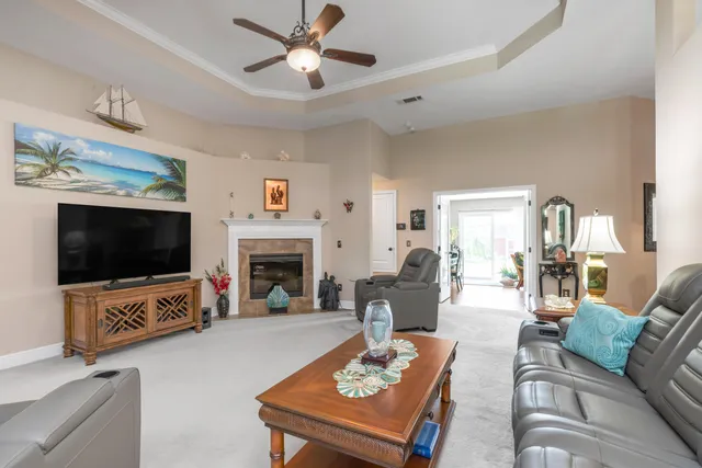 a living room with furniture a flat screen tv and a fireplace