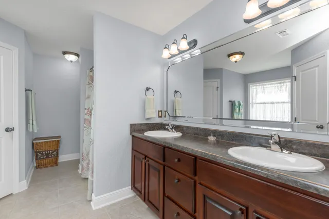 a bathroom with a granite countertop sink a light fixture and a mirror