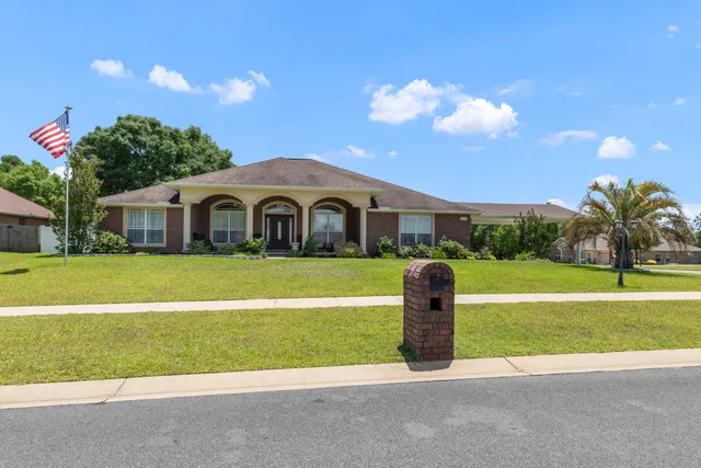 a front view of a house with a garden and yard