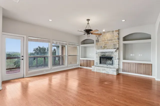 a view of empty room with wooden floor and fireplace