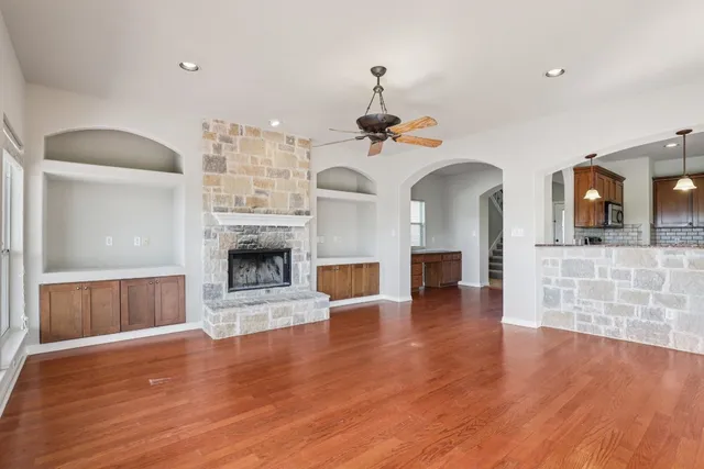 a view of a livingroom with wooden floor and a fireplace