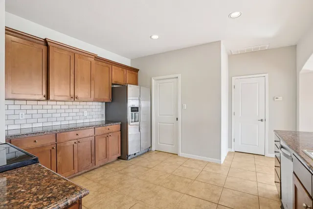 a spacious bathroom with a granite countertop sink and a refrigerator