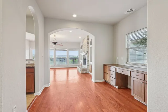 a view of a hallway with wooden floor and a fireplace
