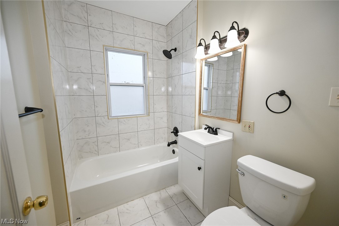 3832 Silsby Road Cleveland, OH 44111 - Photo 9 of 21 Full bathroom featuring tiled shower / bath combo, oversized vanity, toilet, and tile floors