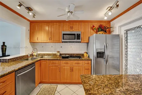 a kitchen with stainless steel appliances granite countertop a stove top oven a sink and dishwasher