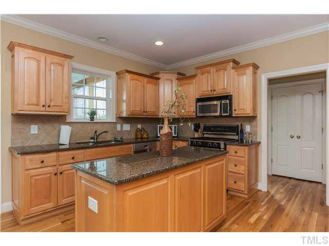 5820 Turner Store Lane Raleigh, NC 27603 - Photo 7 of 25 Huge chef's kitchen w/ all the extras - hardwoods, granite counters, 42" upgraded double level cabinets with detailed arches, brushed nickel hardware, recessed lighting, diagonal tile backsplash, crown molding, double stainless sink with upgraded faucet.