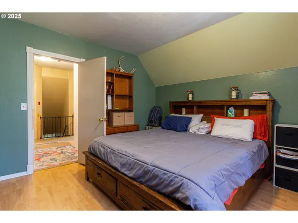 a bedroom with a bed and a large mirror on dresser