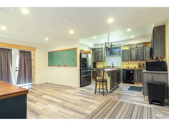 a view of a kitchen with kitchen island a counter top space a sink stainless steel appliances and cabinets