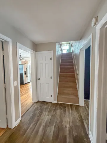 a view of a hallway with wooden floor and staircase