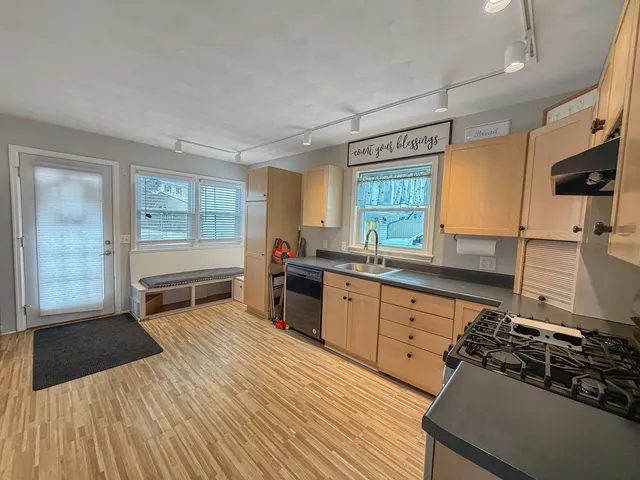 a large kitchen with stainless steel appliances granite countertop a large counter top a stove and a refrigerator