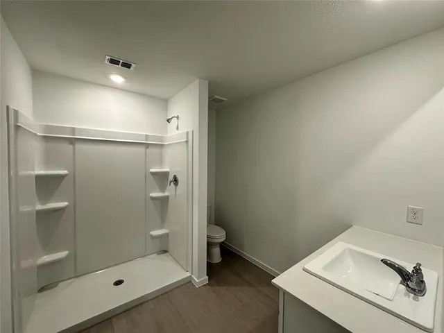 a bathroom with a shower and toilet