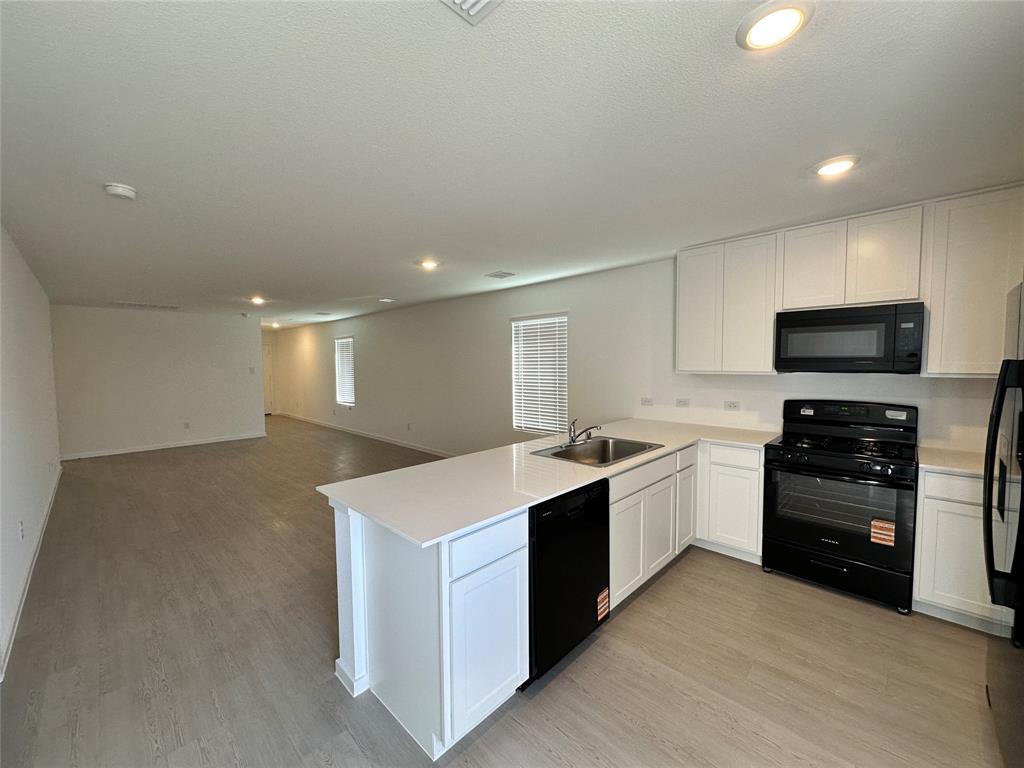 1034 Raintree Road Princeton, TX 75407 - Photo 17 of 17 a kitchen with stainless steel appliances kitchen island hardwood floor sink and stove