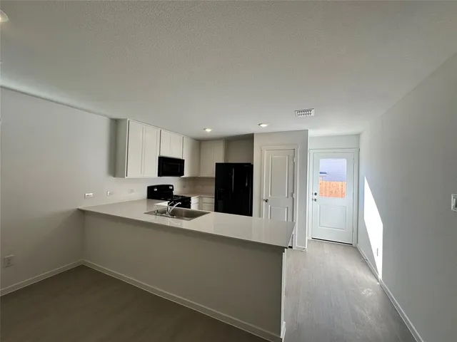 a kitchen with stainless steel appliances kitchen island hardwood floor sink and stove