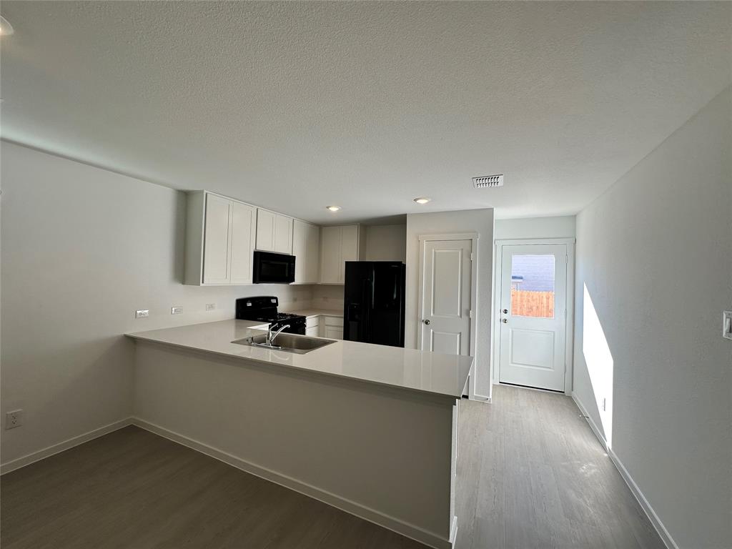 1034 Raintree Road Princeton, TX 75407 - Photo 4 of 17 a kitchen with a sink and refrigerator