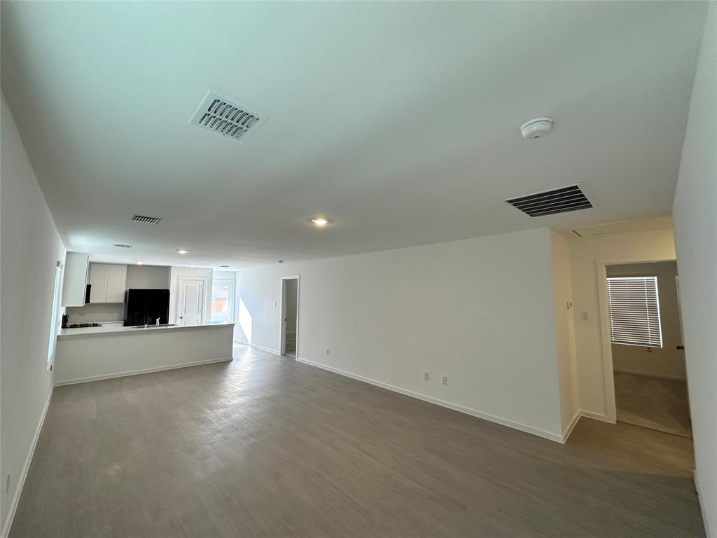 1034 Raintree Road Princeton, TX 75407 - Photo 5 of 17 an empty room with kitchen and fireplace