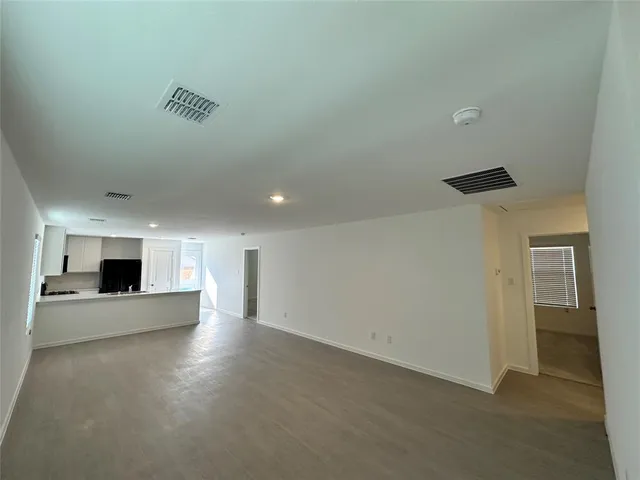 an empty room with kitchen and fireplace
