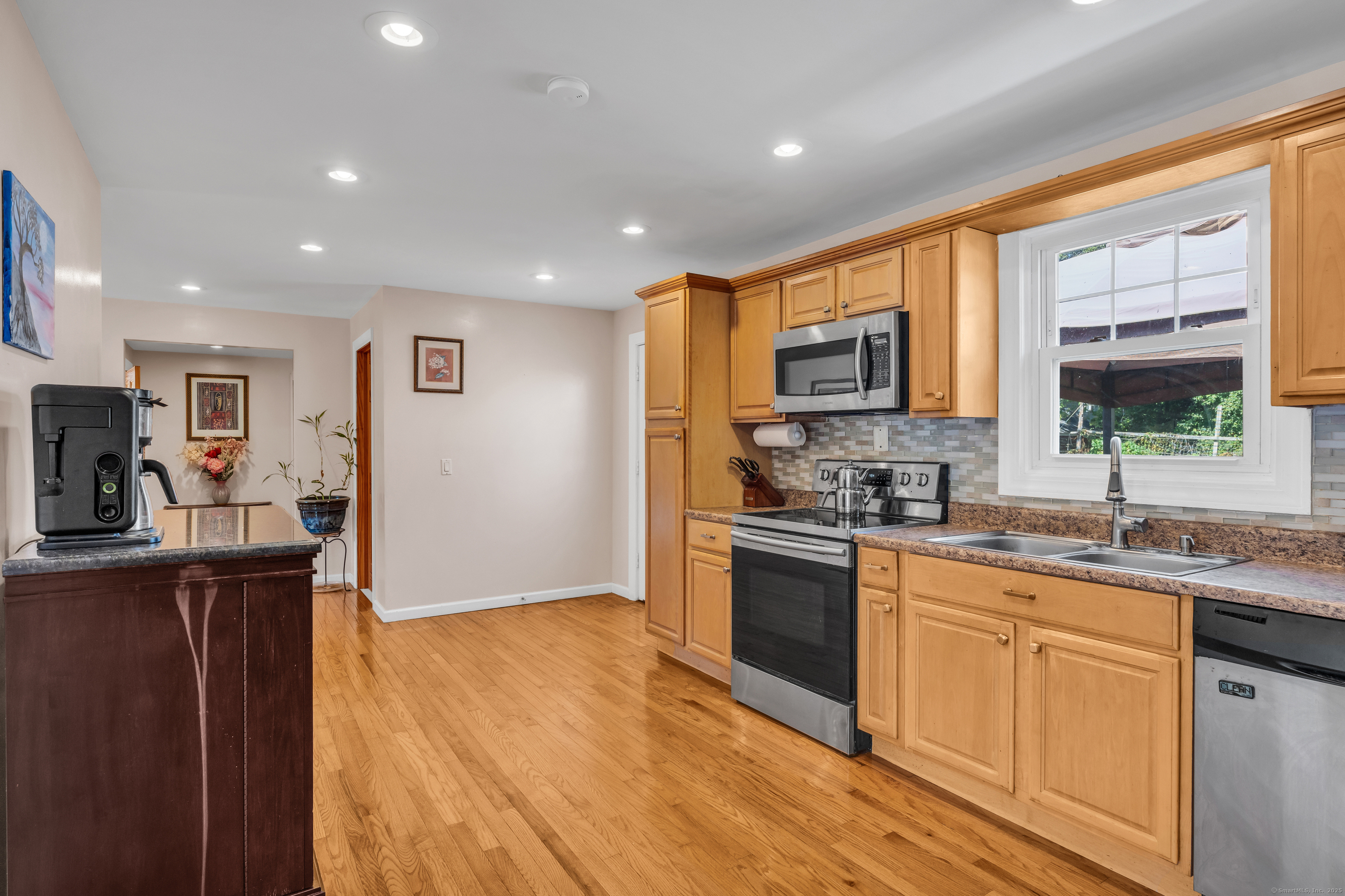 64 Dohm Avenue Guilford, CT 06437 - Photo 10 of 38 a kitchen with stainless steel appliances granite countertop a sink stove microwave and refrigerator