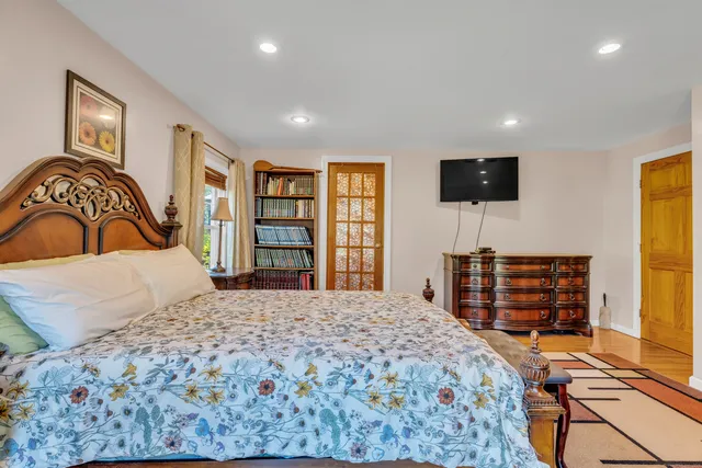 a bedroom with a bed and wooden floor