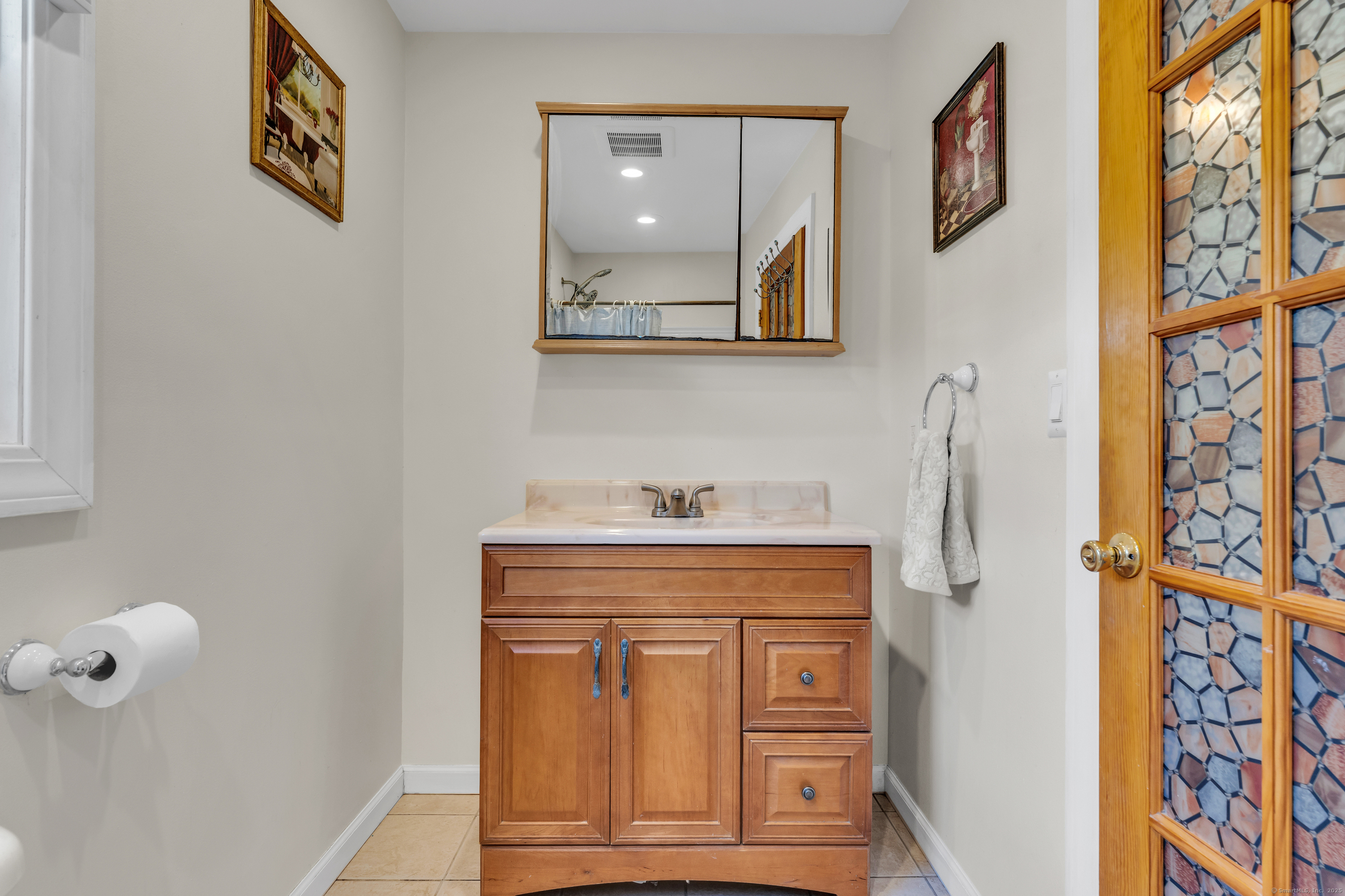 64 Dohm Avenue Guilford, CT 06437 - Photo 17 of 38 a bathroom with a granite countertop sink a vanity and a mirror