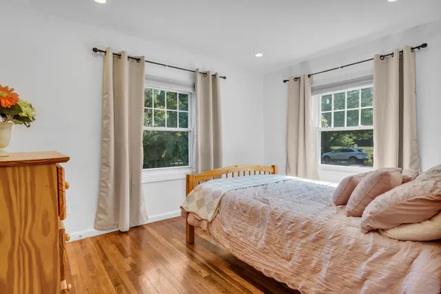 a bedroom with a large bed and a flat tv screen on dresser